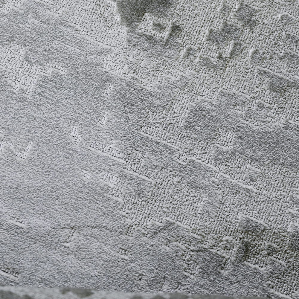 Textured gray woven rug with abstract pattern for contemporary home styling.