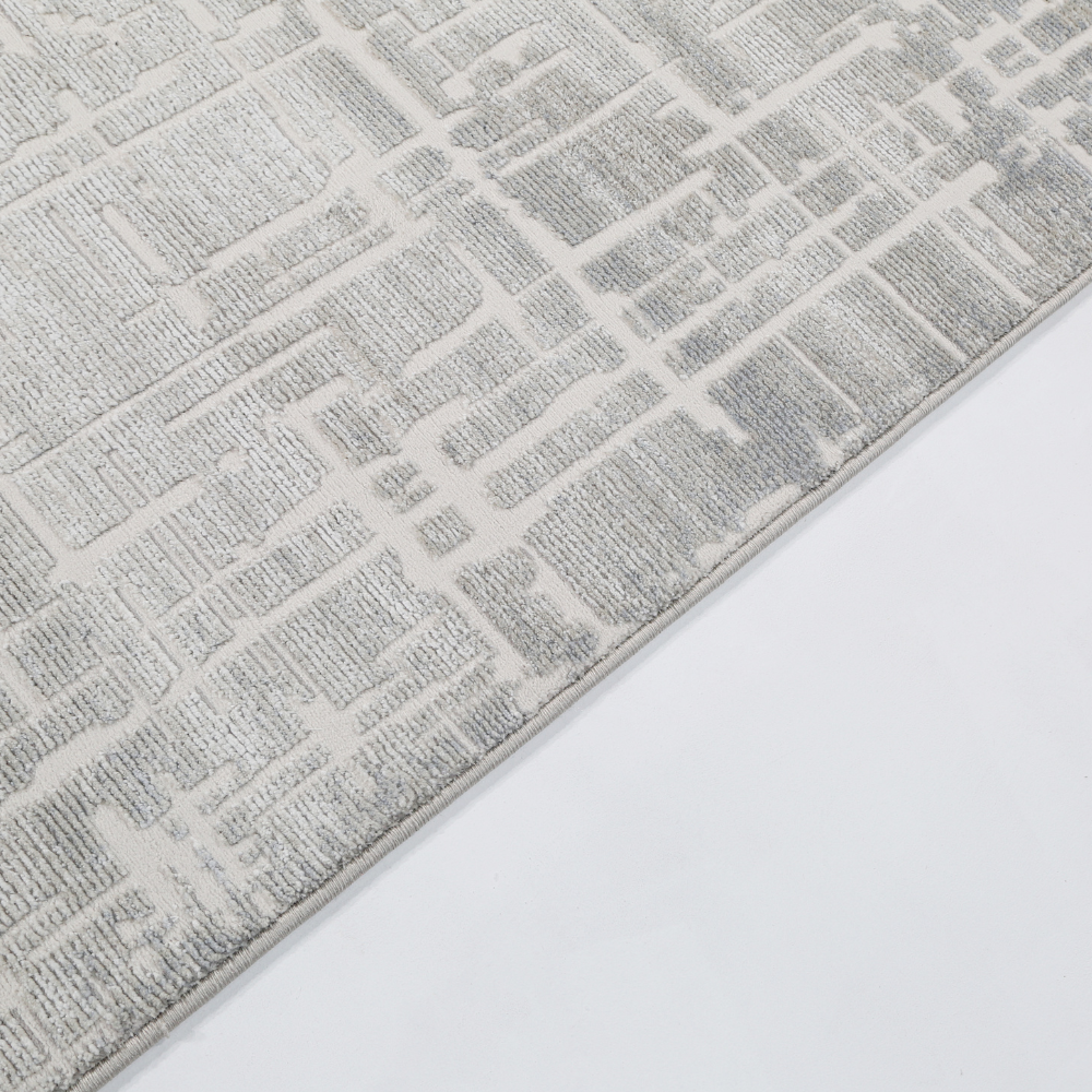 Fading Embers modern woven rug with gray geometric pattern in soft lighting.
