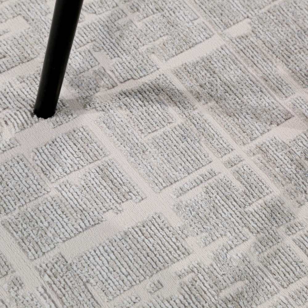 Textured gray woven rug with modern pattern under a chair leg