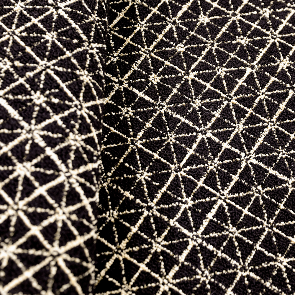 Black and cream geometric woven rug with intricate star pattern for modern decor