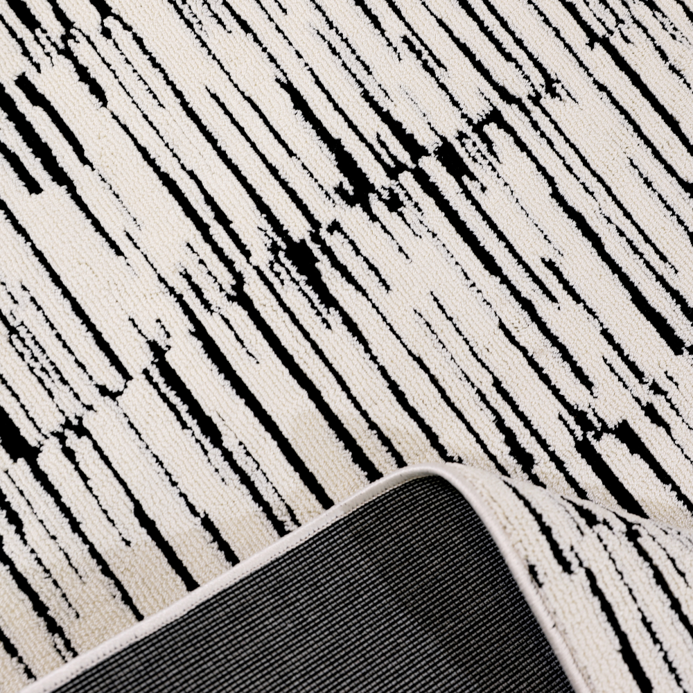 Close-up of Shattered Illusions modern woven rug in black and white textured pattern.
