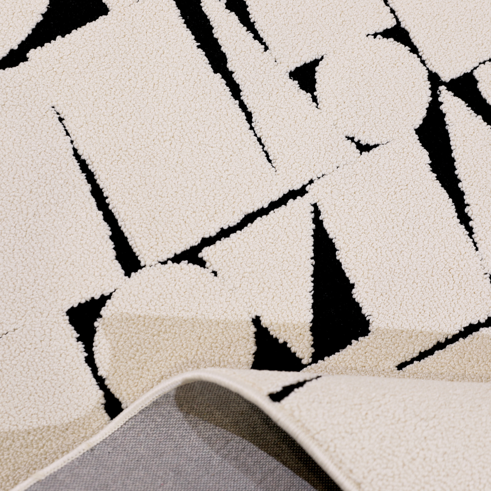 Contemporary cream rug with bold black geometric patterns, ideal for modern decor.