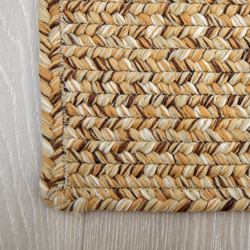 Textured tan and cream hand-braided rug suitable for indoor and outdoor spaces.