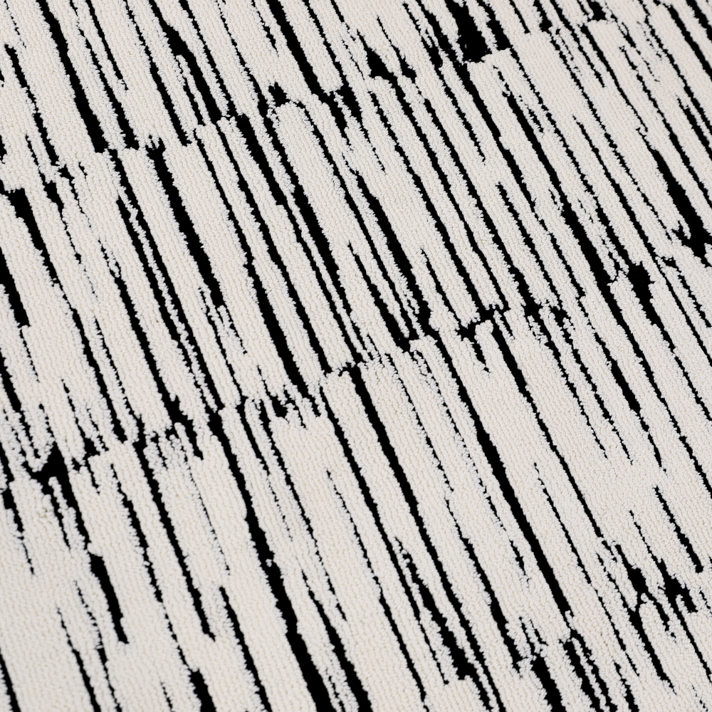 Close-up of Shattered Illusions woven rug in black and white abstract pattern.