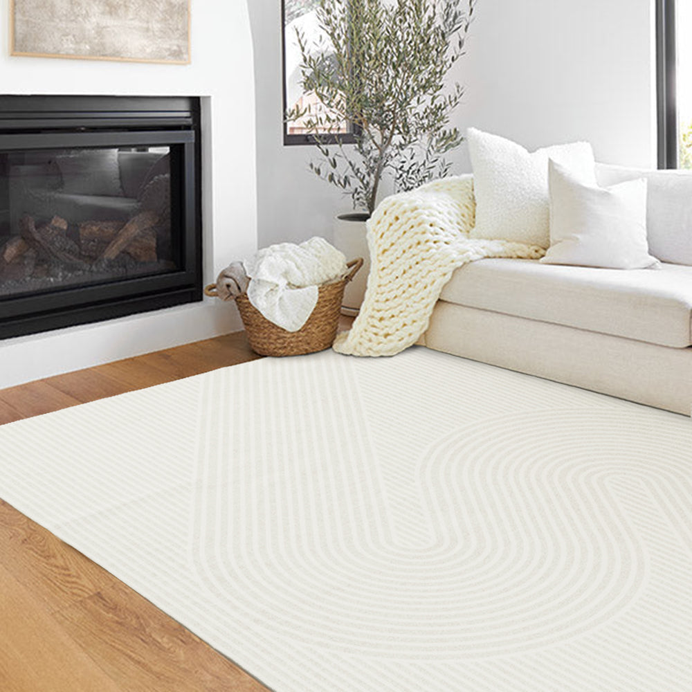 Light-toned Serpentine Whisper rug with curved lines in a cozy living room by the fireplace