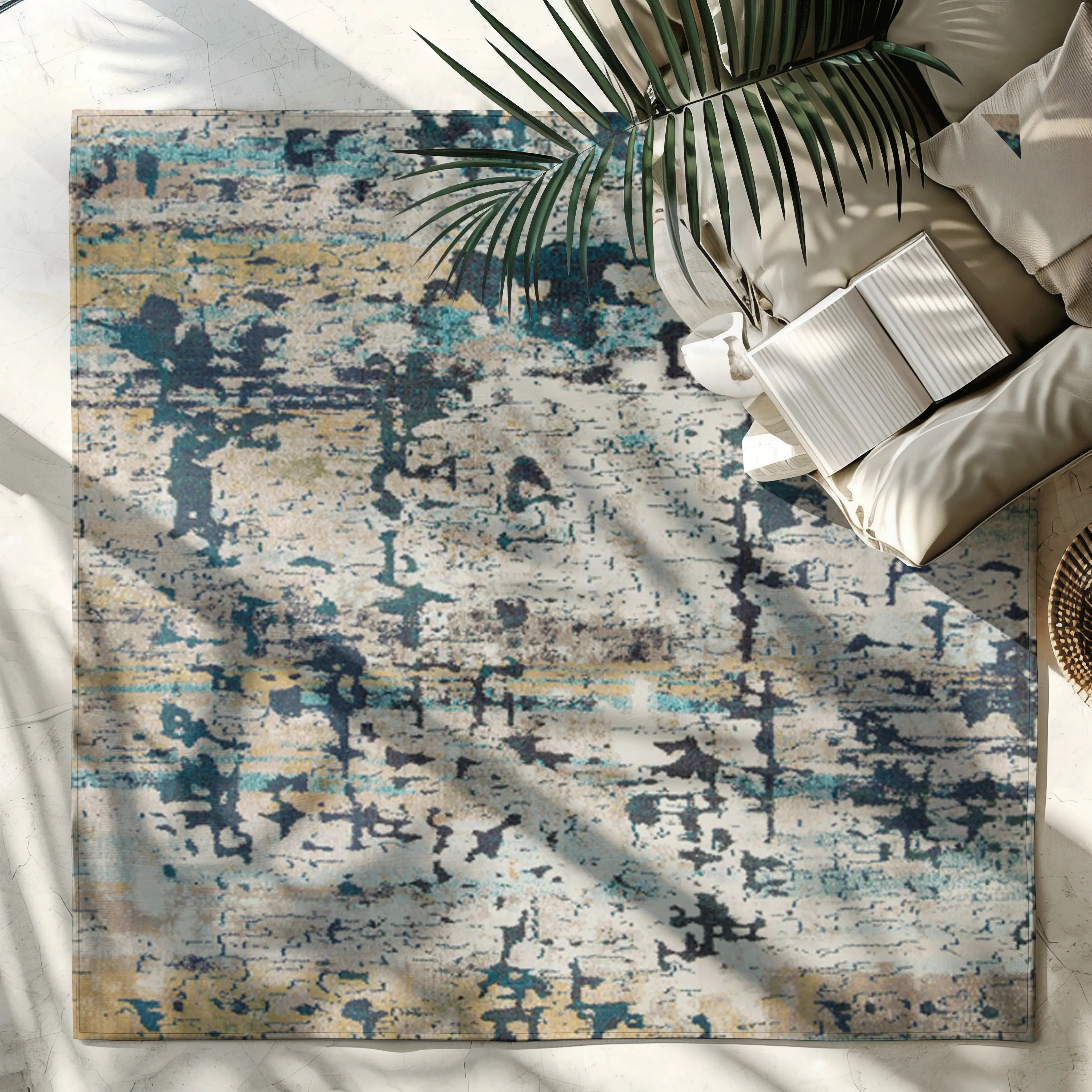 Abstract blue and beige Mystic Lagoon rug on light floor with palm and book