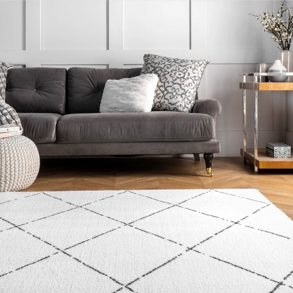 Stylish geometric diamond pattern washable rug in white and black in a cozy living room.