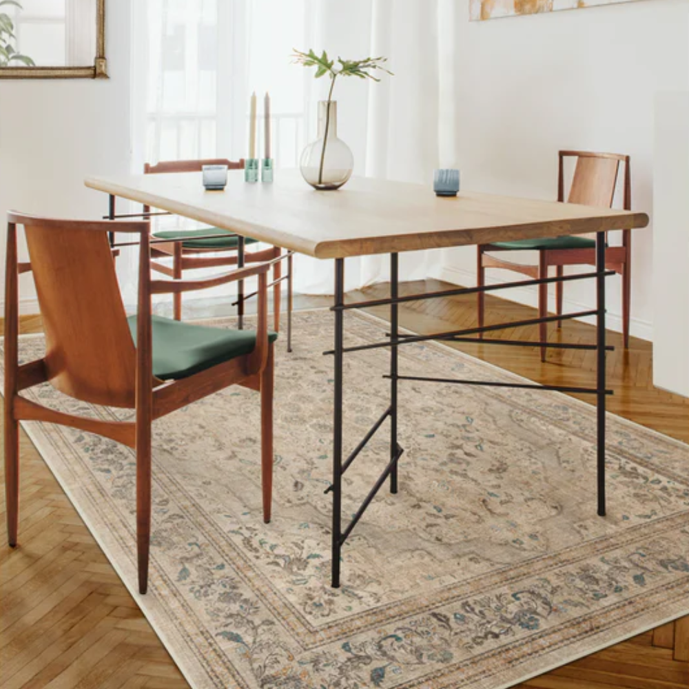 Vintage floral washable rug in beige under a wooden dining table with chairs