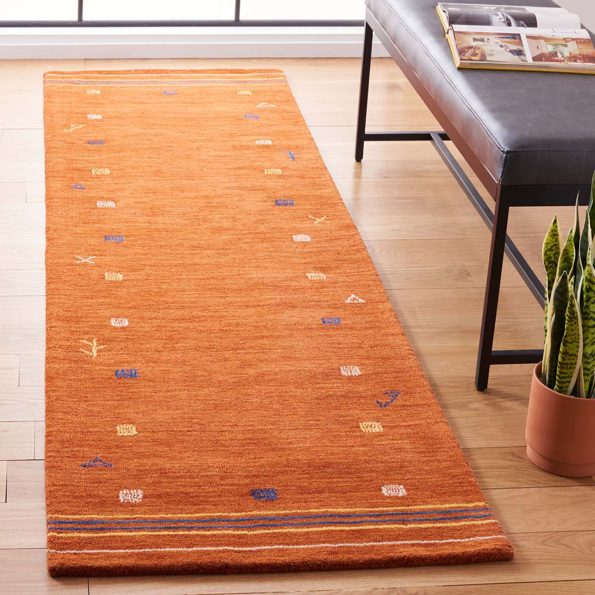 Orange geometric runner rug with colorful accents for modern home decor.
