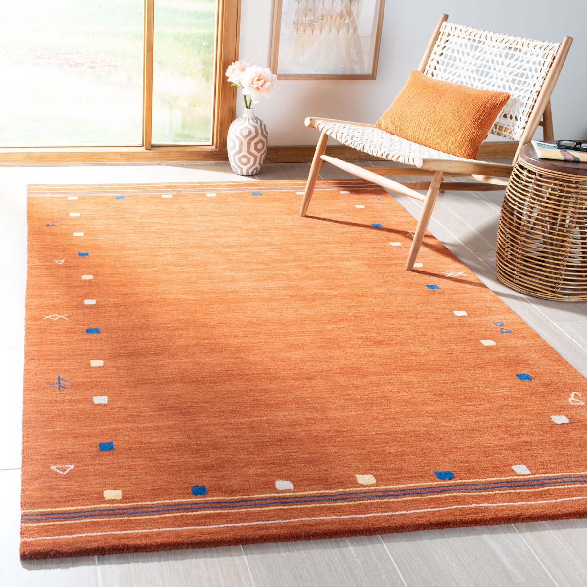 Vibrant orange geometric washable rug with blue and cream accents for modern interiors.