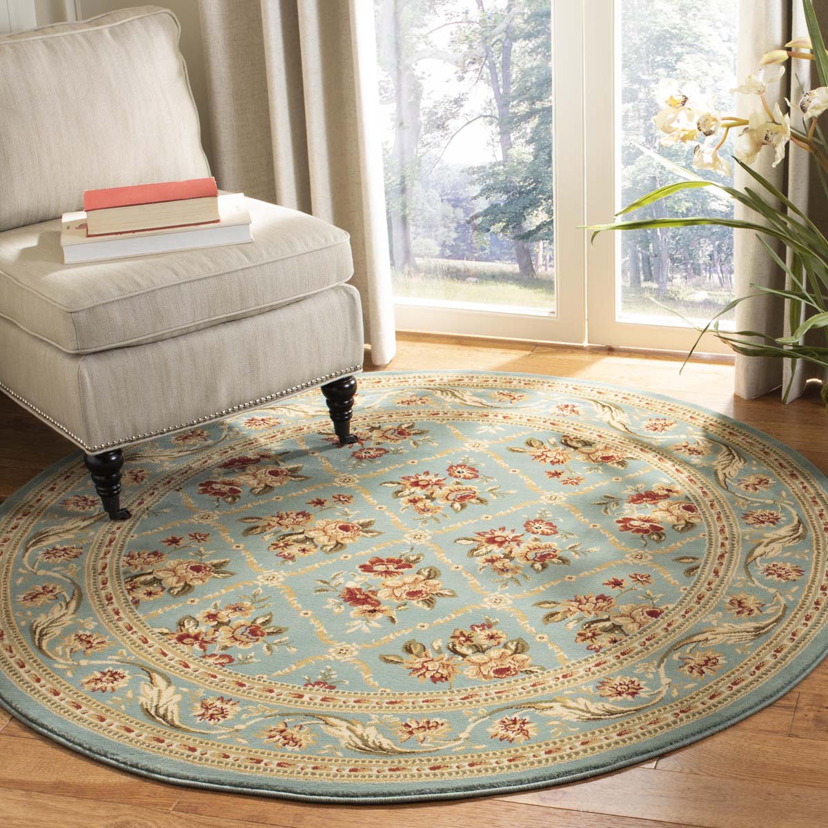 Round vintage floral rug in blue, red, and gold, enhancing a bright living room decor.