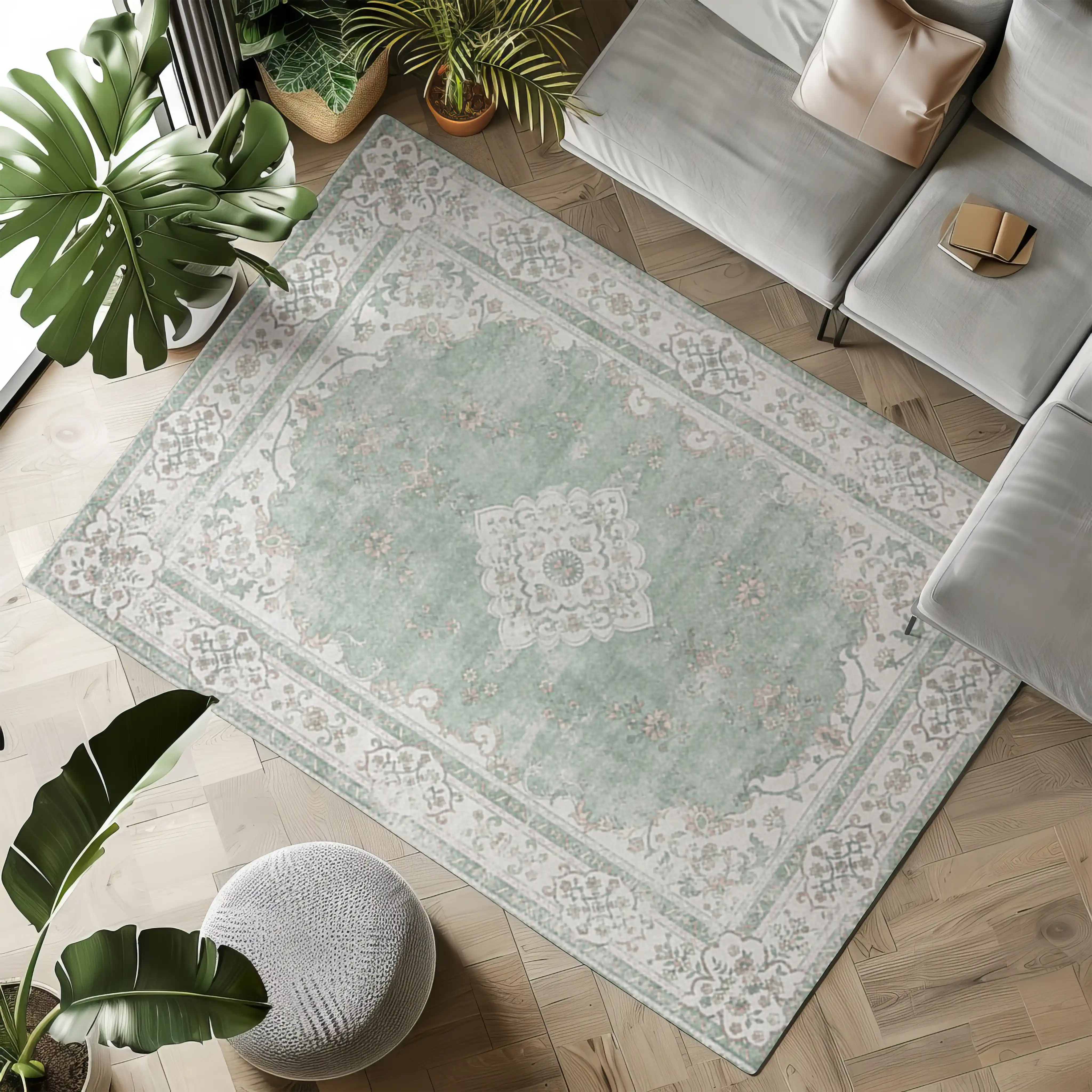 Soft green vintage rug with floral pattern and ornate border in a cozy living room.
