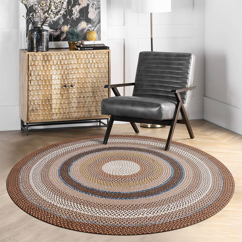 Ringed Circle Vintage Outdoor Woven Rug in vibrant colors on wooden floor with chair.