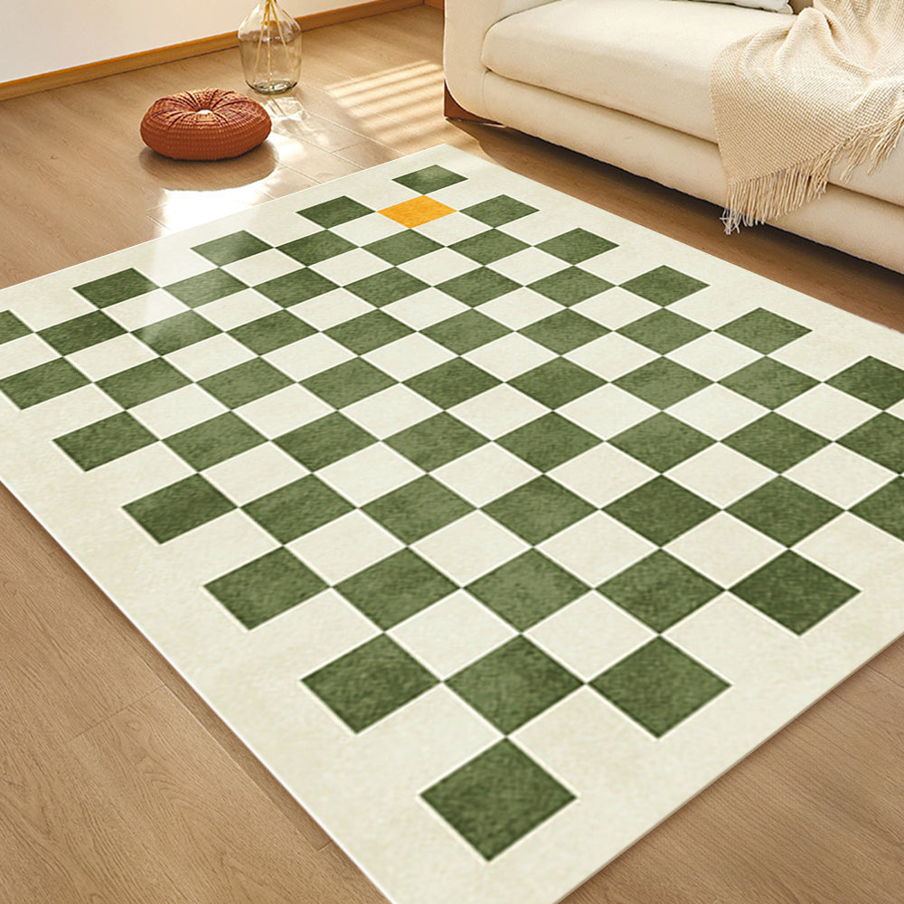 Green and beige checkerboard rug with orange accent in bright living room.