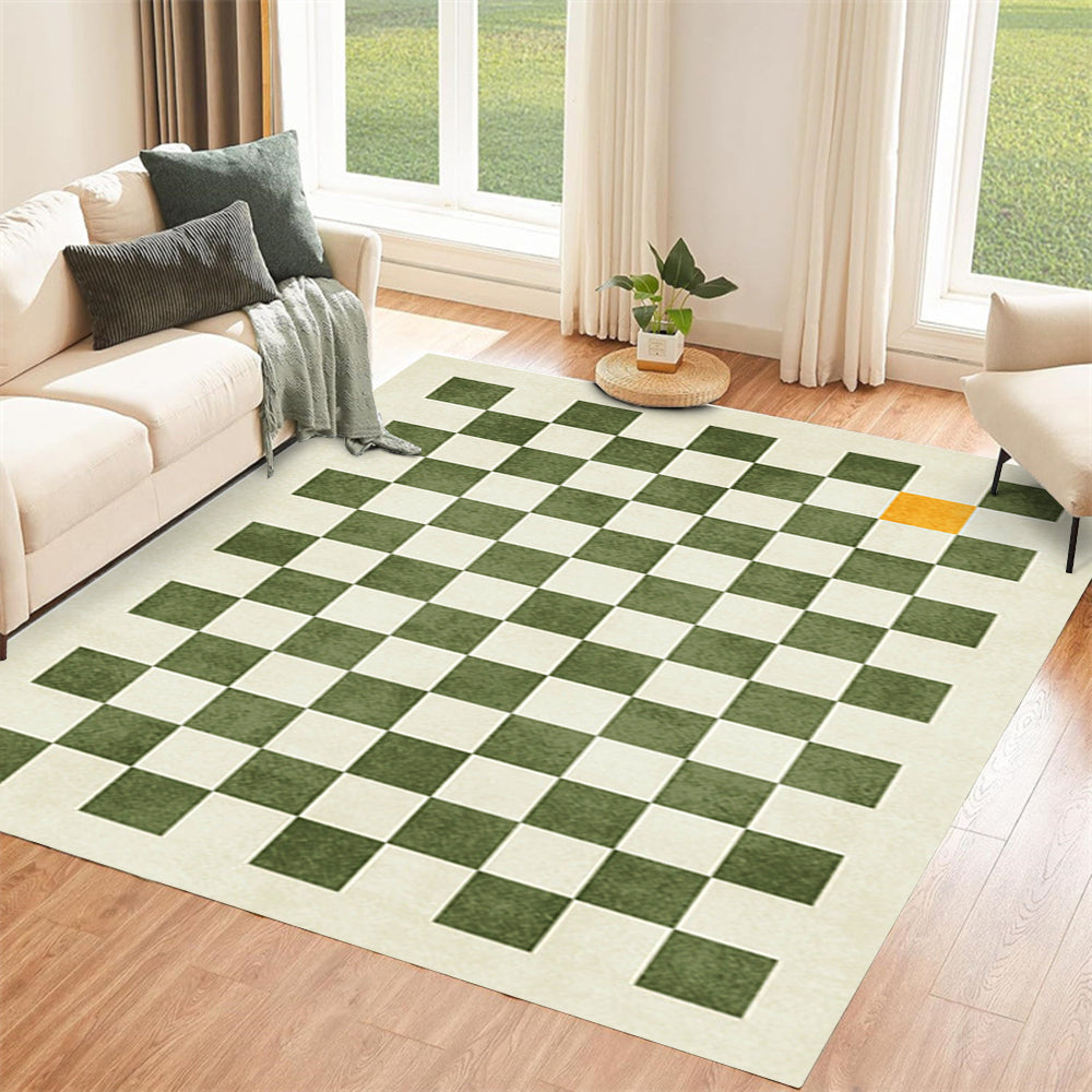 Green and beige checkerboard rug with an orange accent in a bright living room.