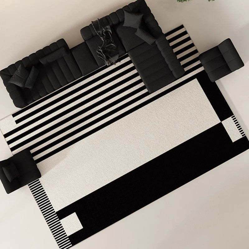 Strian geometric washable rug in black and white under a black sofa set