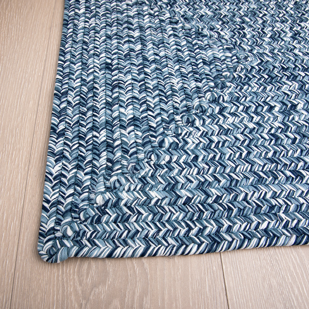 Hand-braided outdoor rug with blue and white chevron pattern on floor
