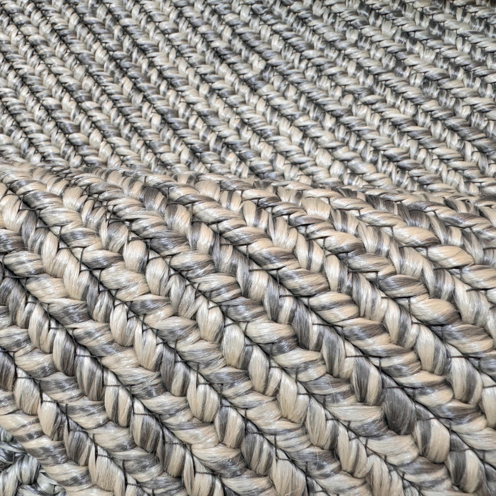 Light gray hand-braided outdoor rug with intricate weave pattern.