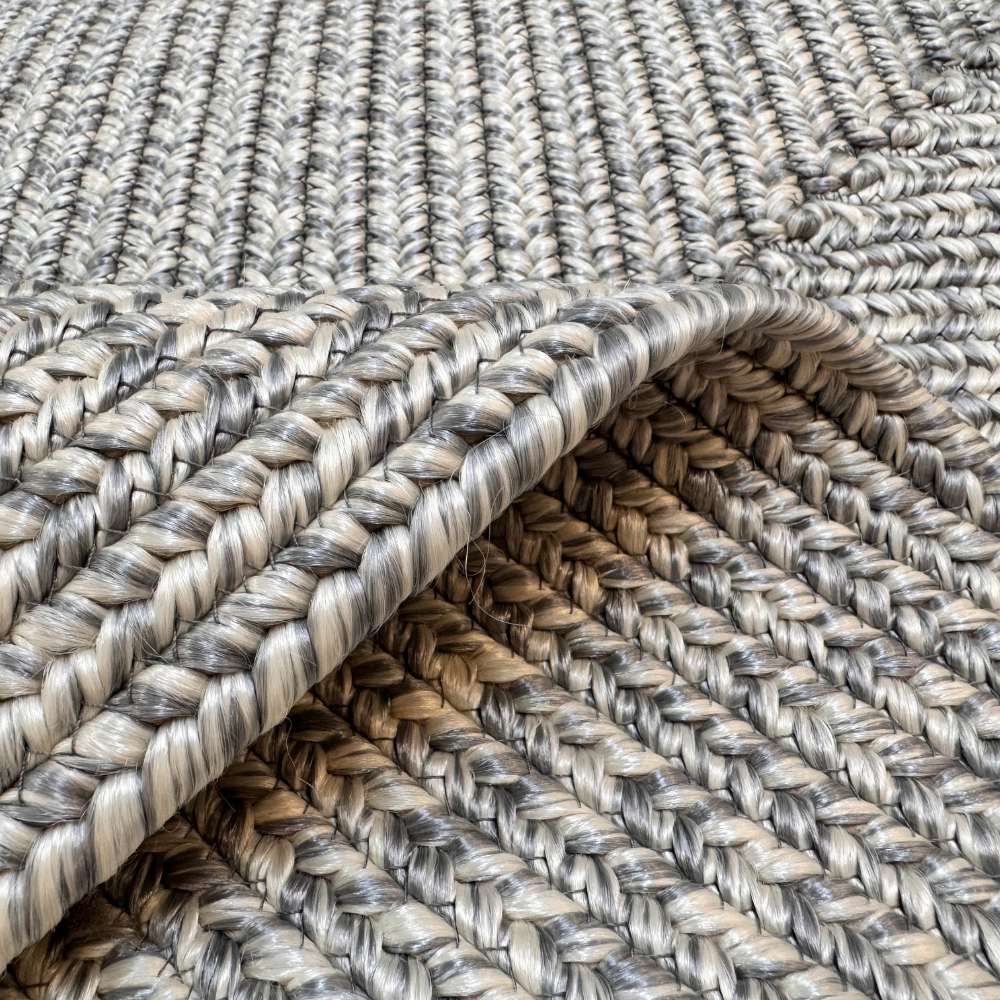 Textured light gray hand-braided rug showcasing intricate weaving.