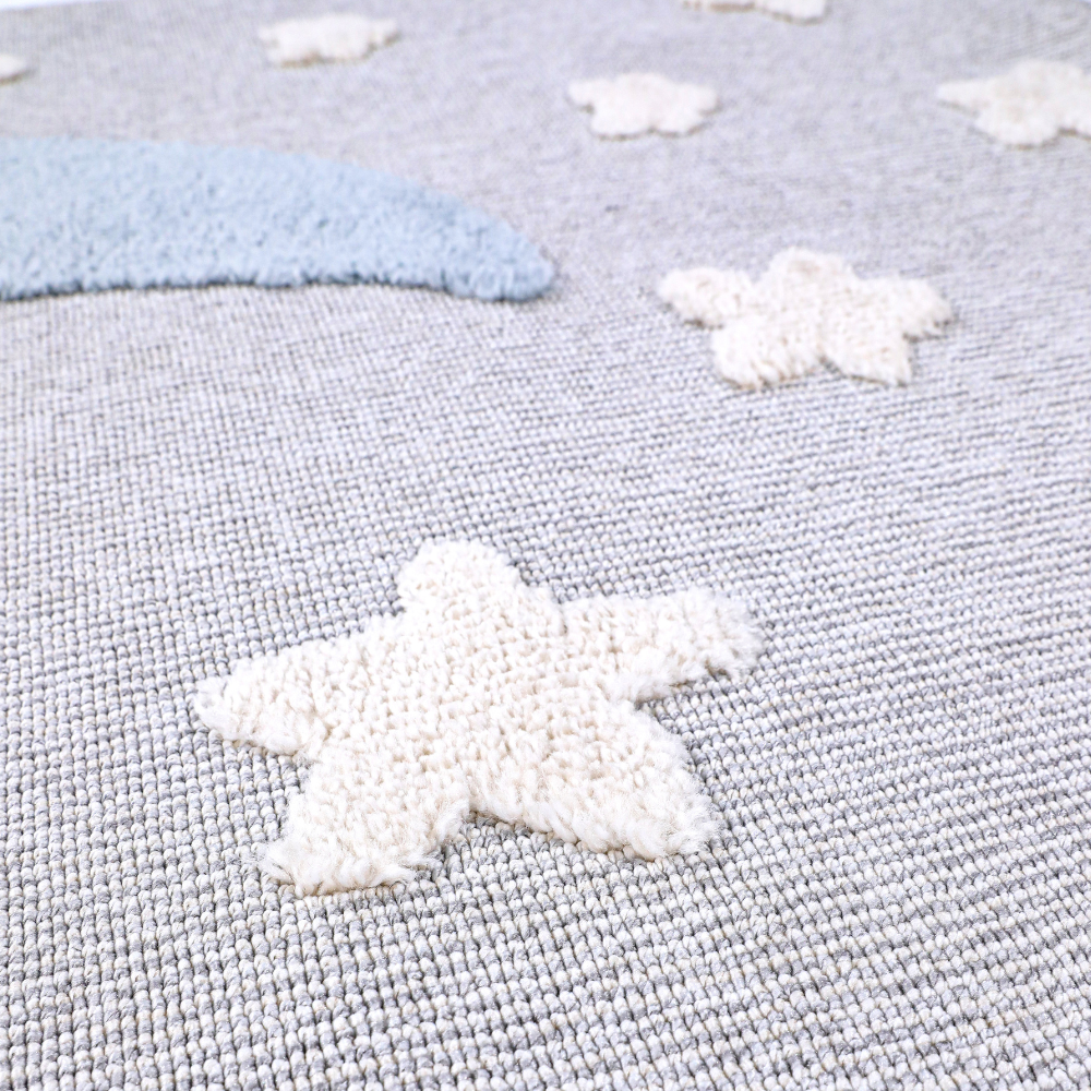 Kids woven rug with fluffy star patterns in soft gray and cream tones.