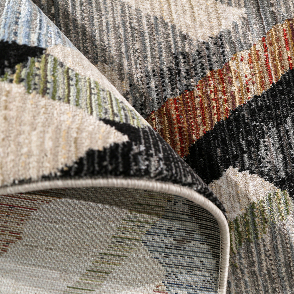 Close-up of a geometric textured rug with colorful abstract patterns.