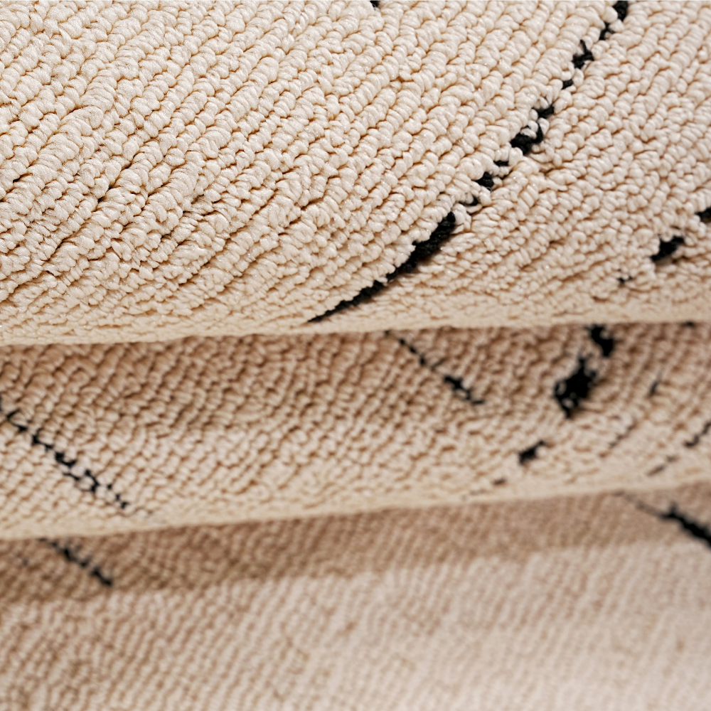 Thane Modern Textured Rug in cream with abstract black patterns.