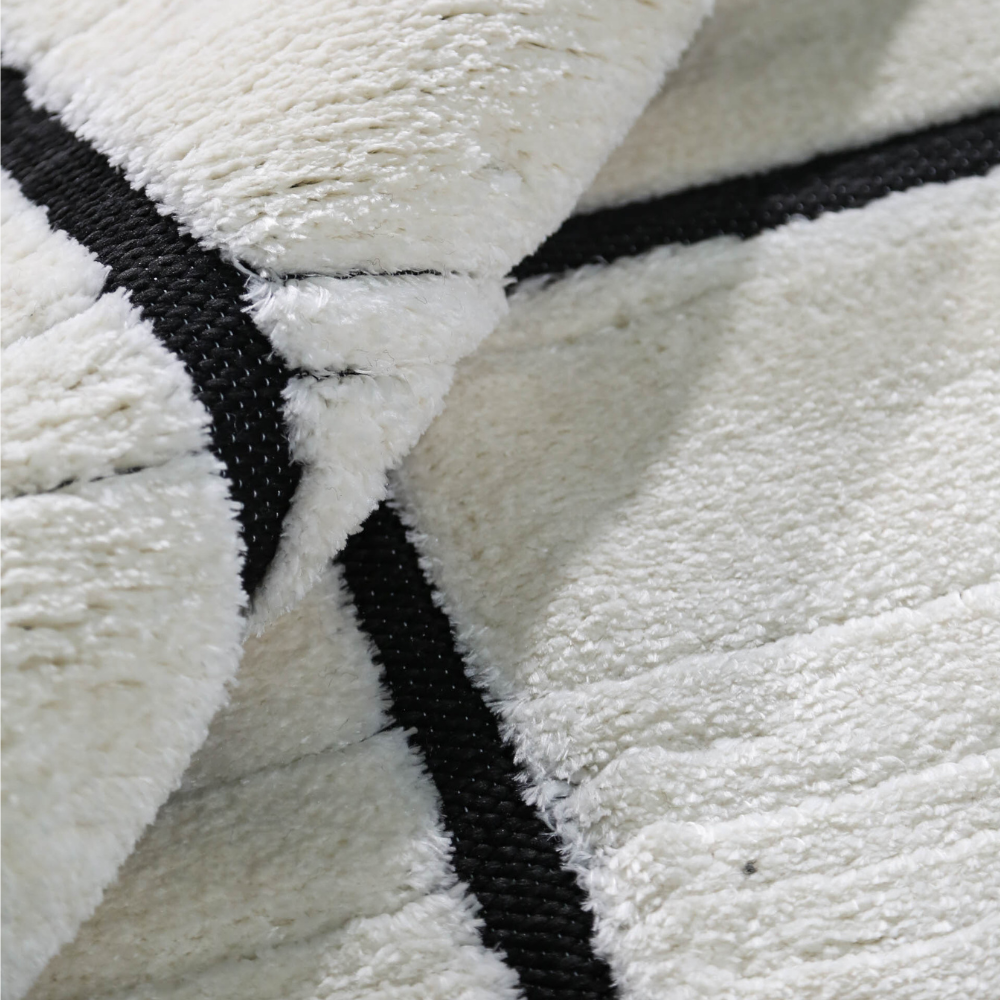 Close-up of Eldrin geometric textured rug in cream and black color scheme