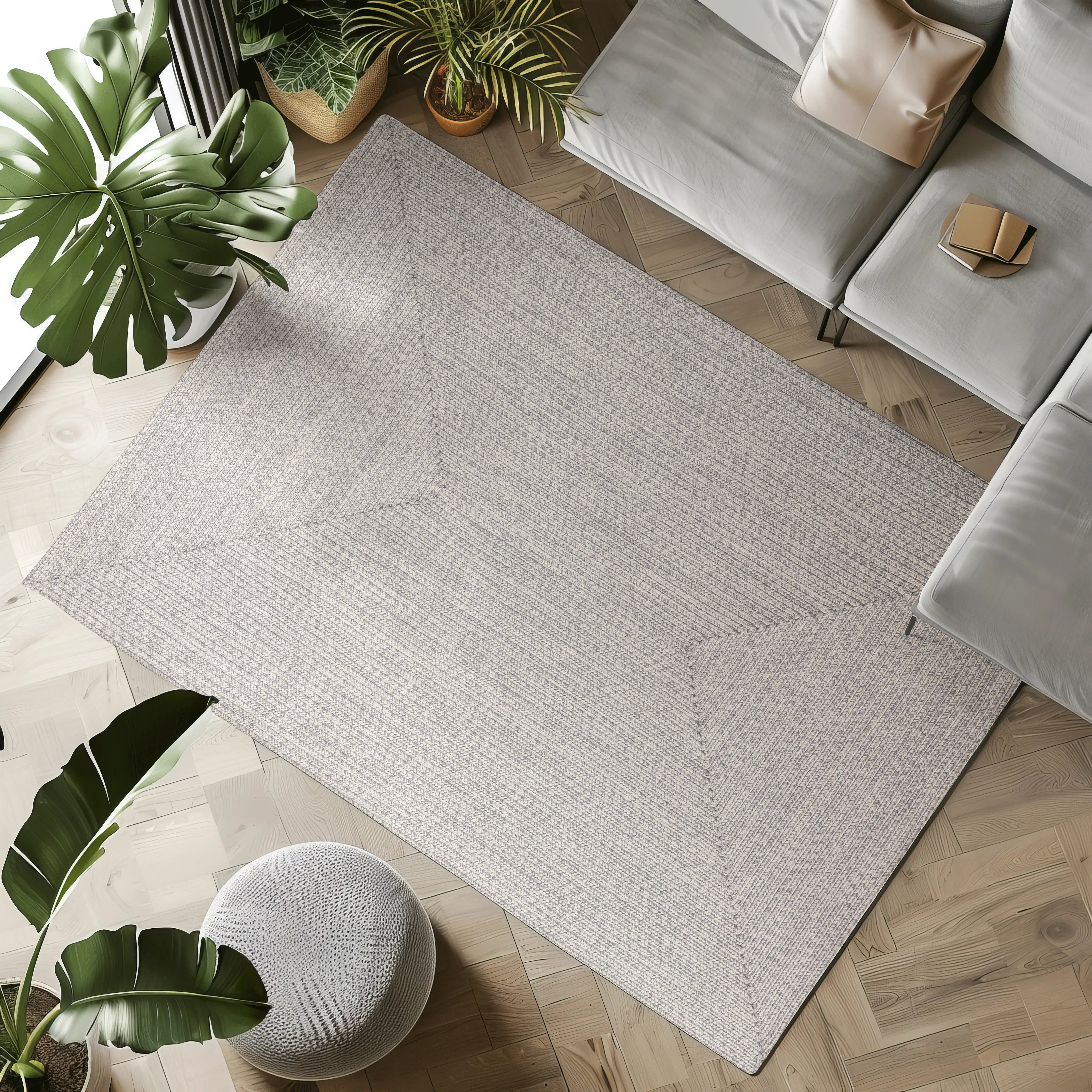 Hand-braided light gray outdoor rug with a textured pattern in a modern living space.