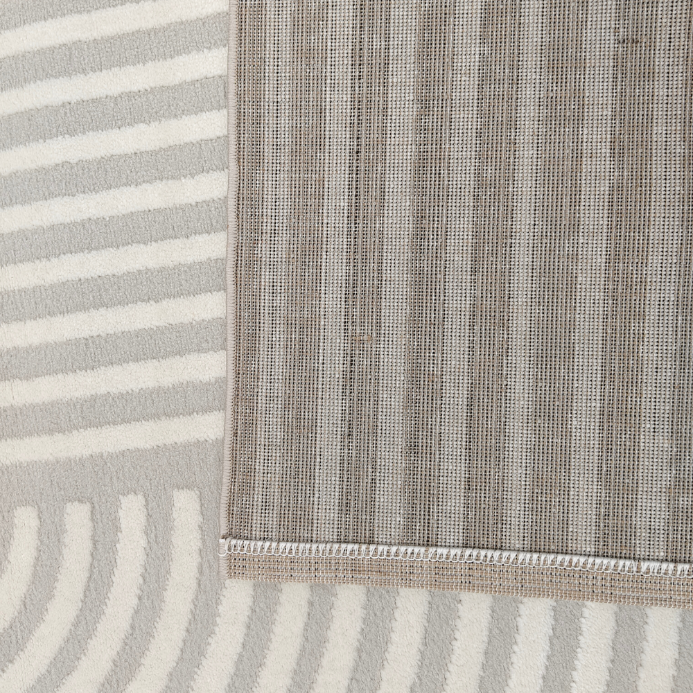 Vero textured rug close-up with grey stripes and cream circular patterns.
