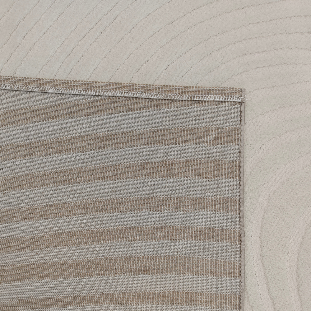 Beige rug with soft wave patterns, ideal for elegant home interiors.