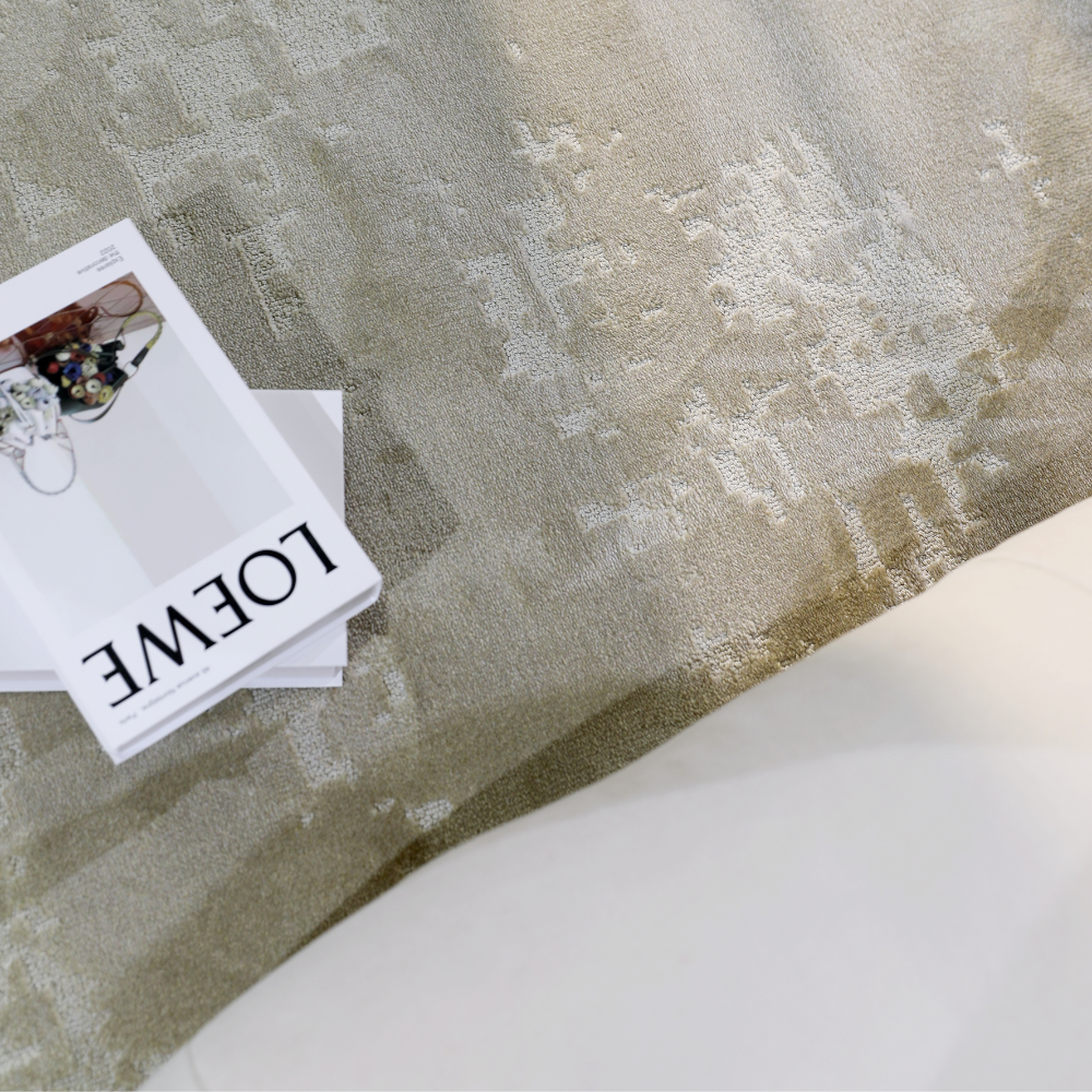 Textured light Radiant Solitude woven rug under coffee table with decor magazine.