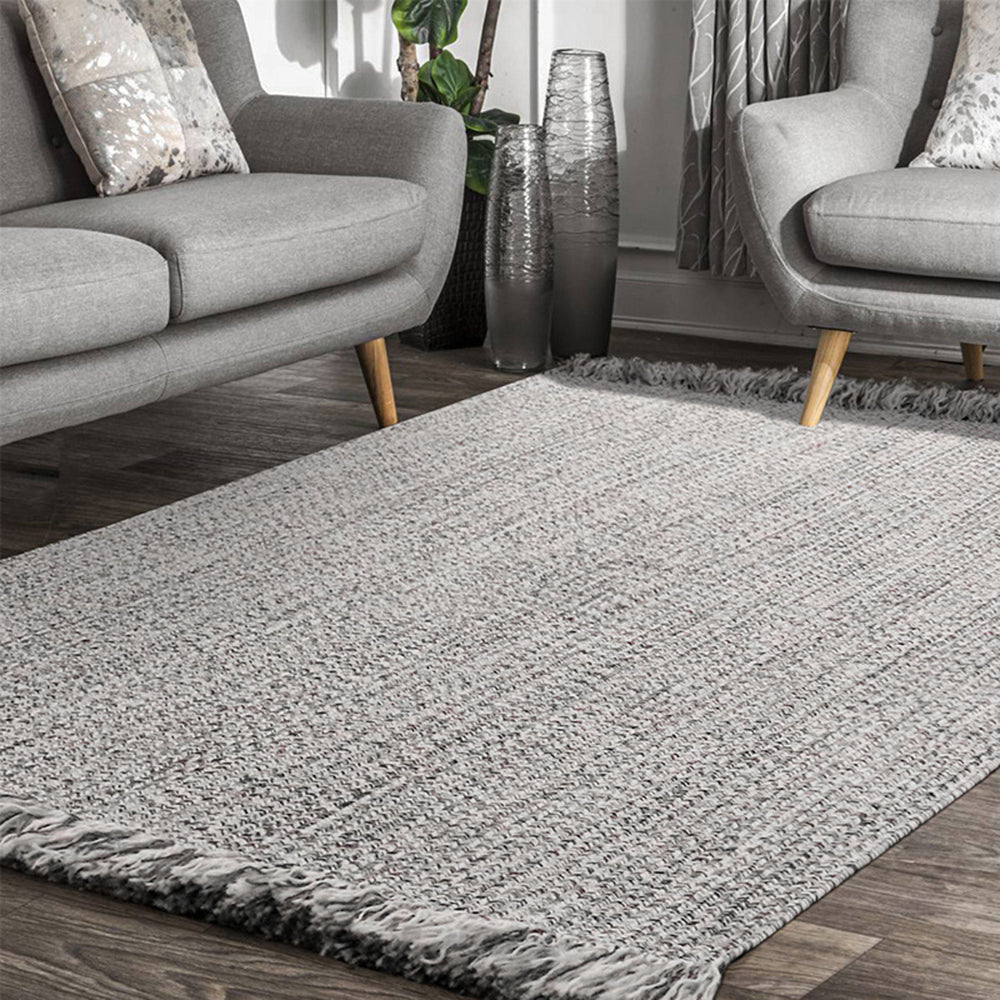 Textured gray rug with tassels in a stylish living room setting