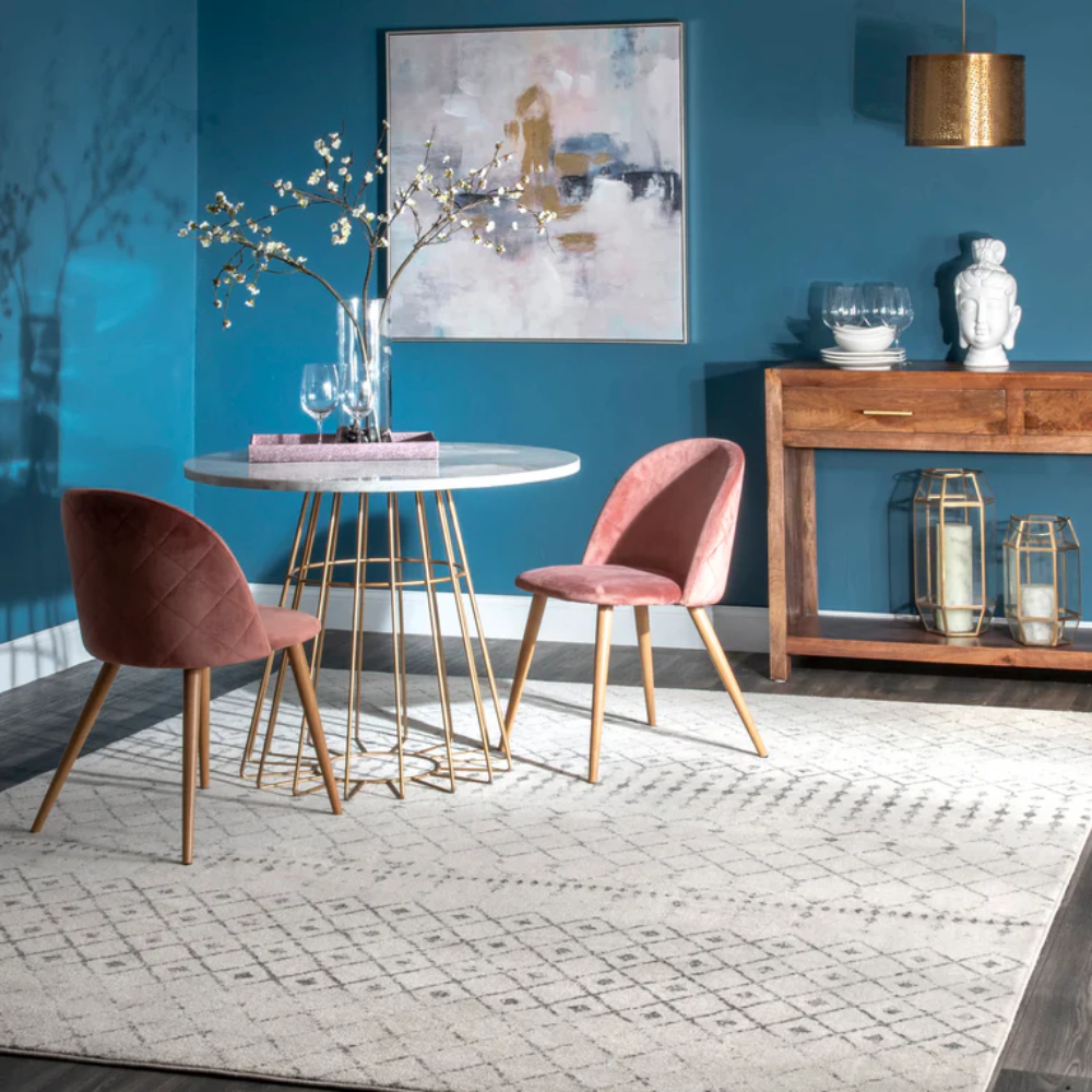 Fiona Moroccan washable rug in gray and cream under a dining table with pink chairs.