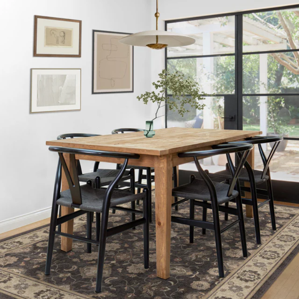 Elegant Persian washable rug enhancing a modern dining space with wooden table and black chairs.