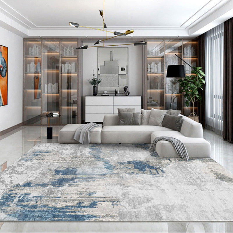 Blue and gray faded abstract washable rug in contemporary living room setting