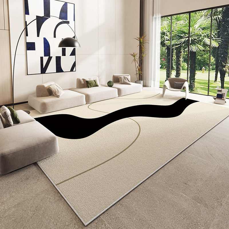 Beige rug with black abstract design in a modern living room setting.