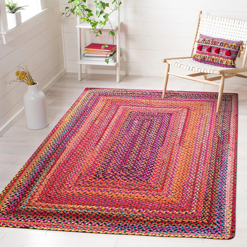 Vibrant pink and orange Bohemian woven rug enhancing a bright living space.
