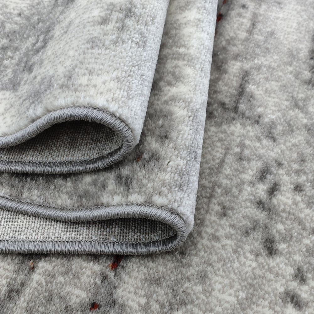 Aurelia Abstract Textured Rug with soft gray and orange detailing.