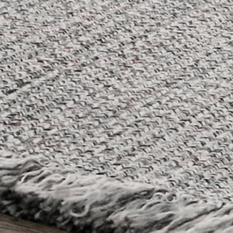 Gray woven outdoor rug with tassels, perfect for stylish home decor.